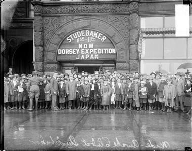 Image Description: Group standing outside the Studebaker Theater entrance on Michigan Avenue. Marquee reads 